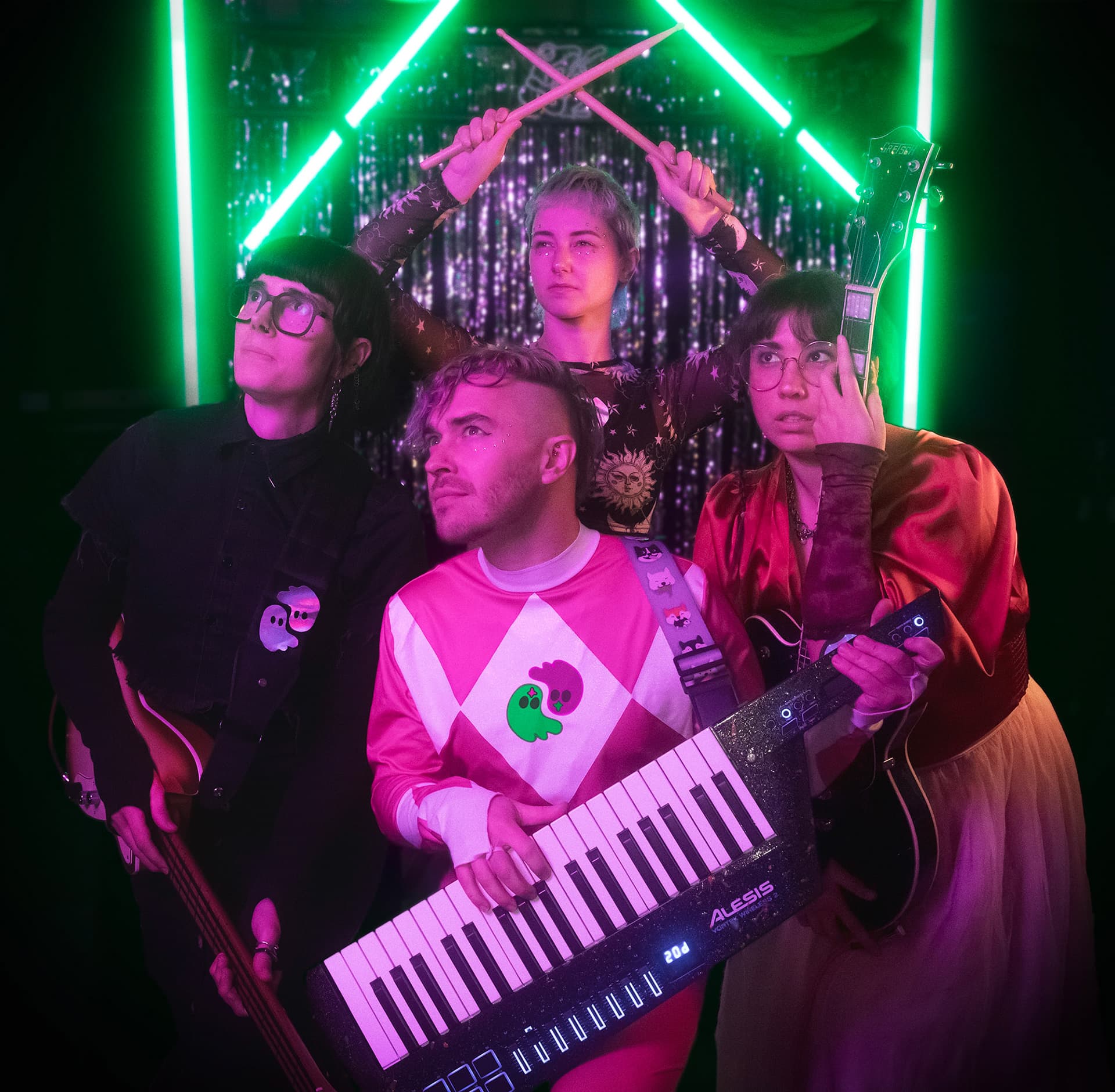The four members of Cosmic Whiplash under pink and green stage lights